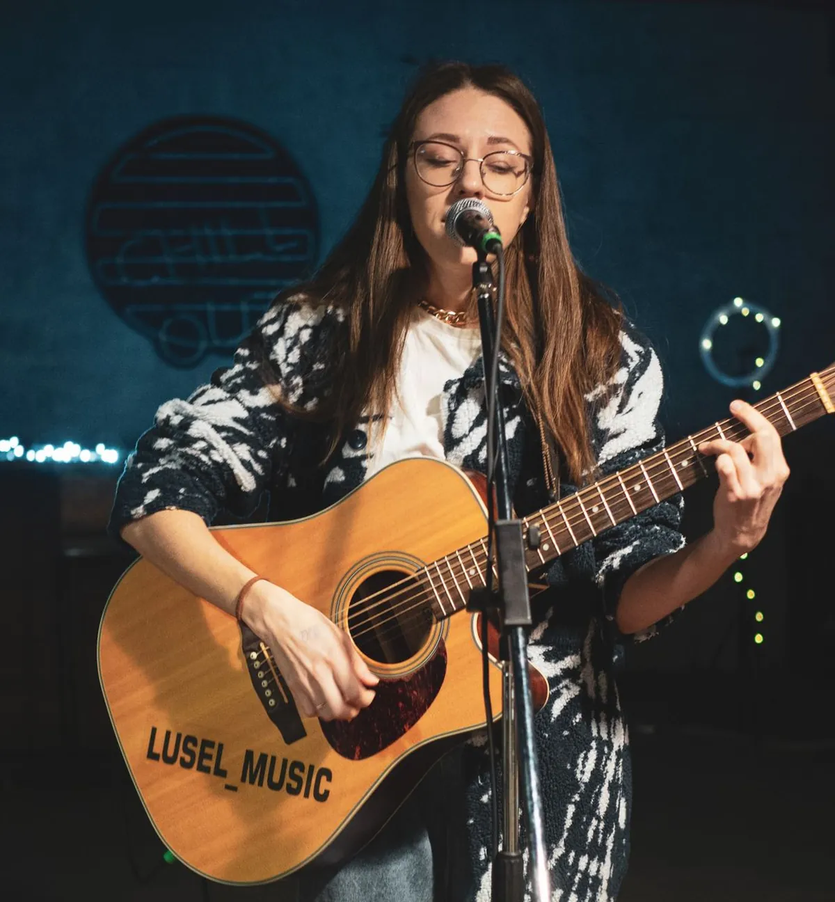 A singer with a guitar on a small stage